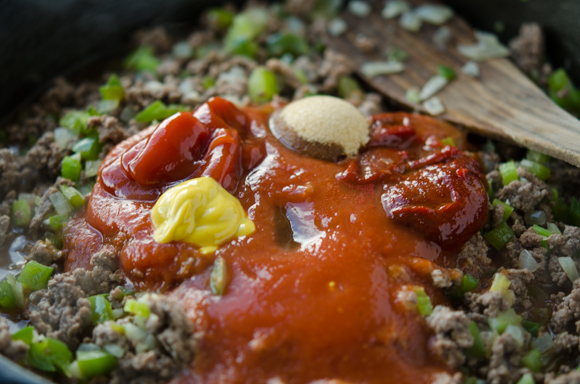 Gochujang and other flavors are added to ground beef and vegetabel mixture in a skillet.