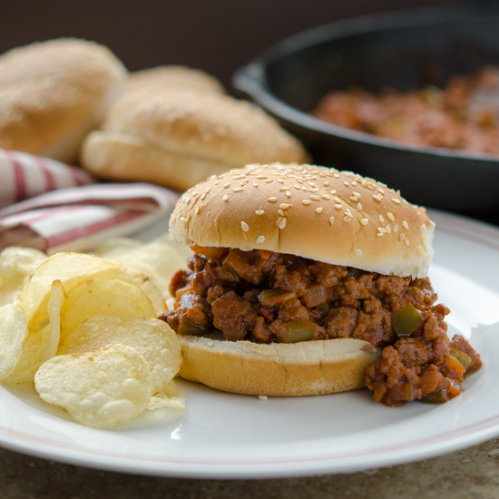 Gochujang sloppy joe sandwich with potato chips.