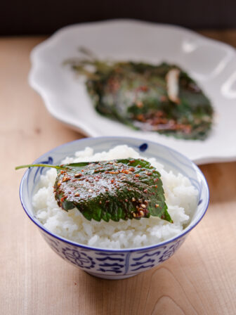 A seasoned and steamed perilla leaf is served over rice.