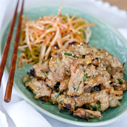 Korean doenjang marinated pork with green onion salad is served together on a plate.