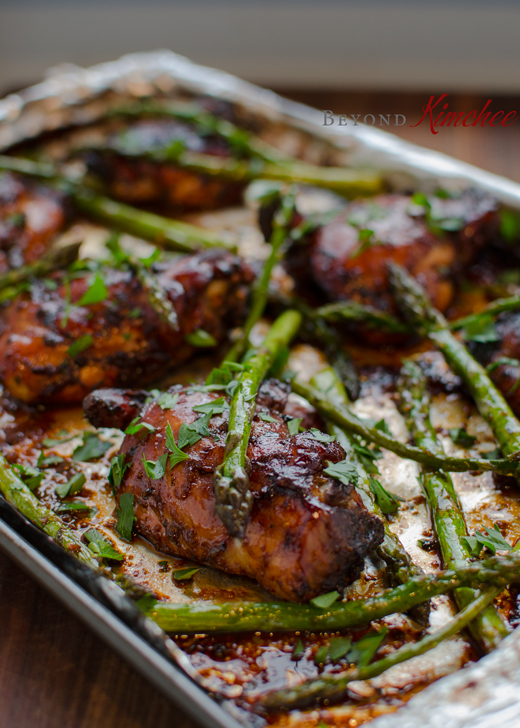 Marinated chicken thighs are baked with asparagus in one pan.