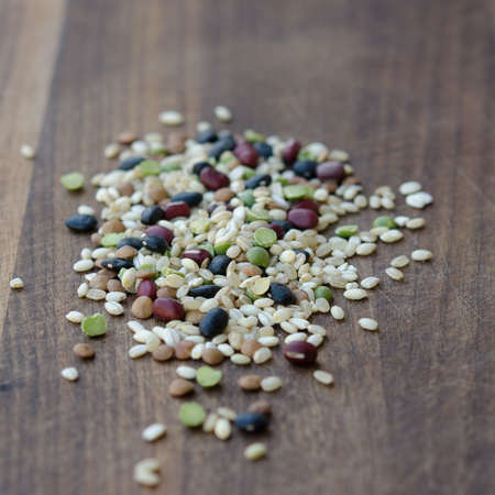 Mixed grain rice with a few legume is placed on a wooden board.