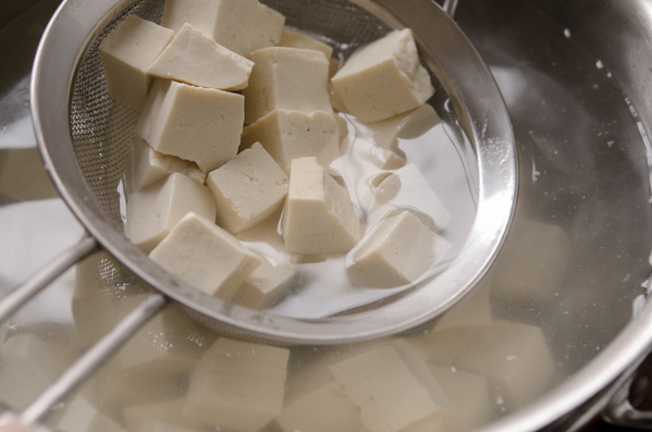 Diced tofu cubes are precooked in boiling water.