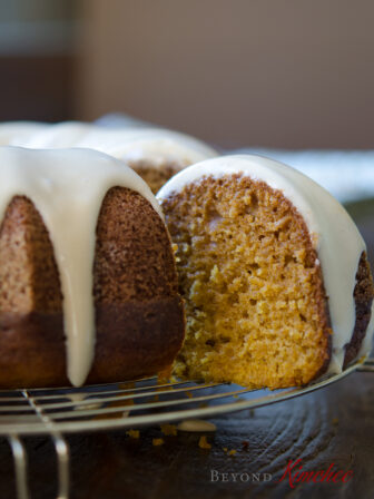 A slice of glazed pumpkin bundt cake with maple glaze has moist, tender crumbs.