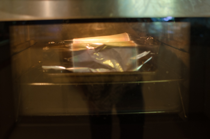 A loose foil tent is placed on top of apple pie in the oven