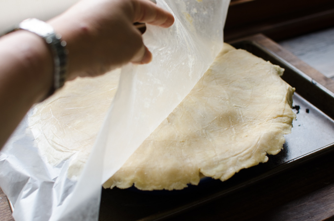 Top pie crust is placed on top of apple pie filling.