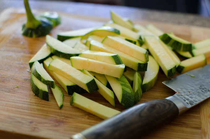 Sliced zucchini on a cutting board.