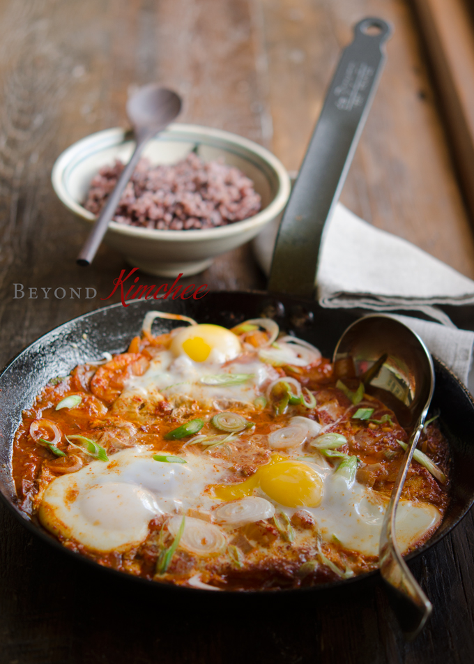 Korean tofu and eggs are cooked in a skillet with spicy sauce to serve with rice.