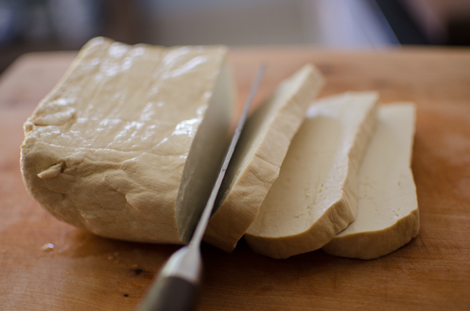 A block of Korean tofu is sliced.