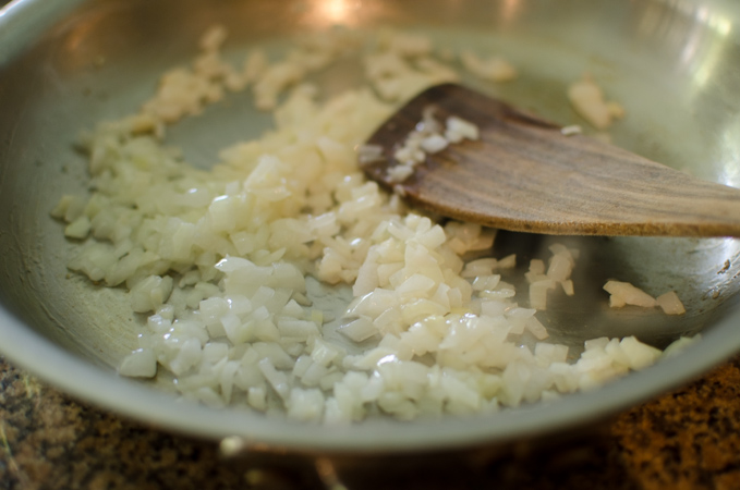 Onion is cooked in a skillet until soft and translucent.