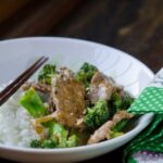 Quick stir-fried beef and fresh broccoli florets are serve with rice.