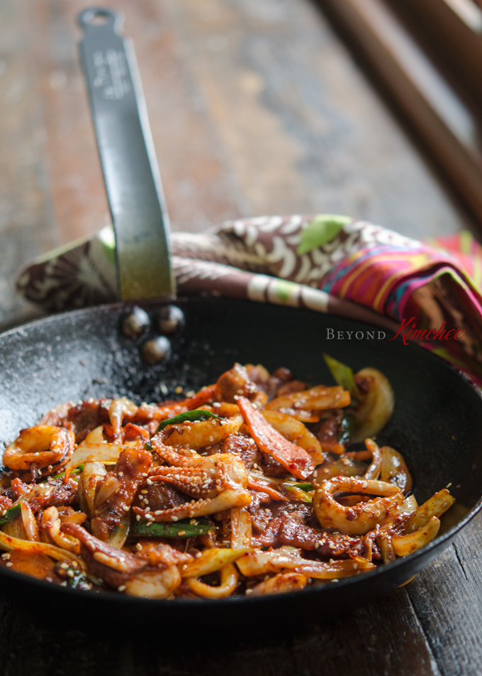 Pork belly and squid are stir-fried in a spicy sauce made with Korean chili paste and curry powder.