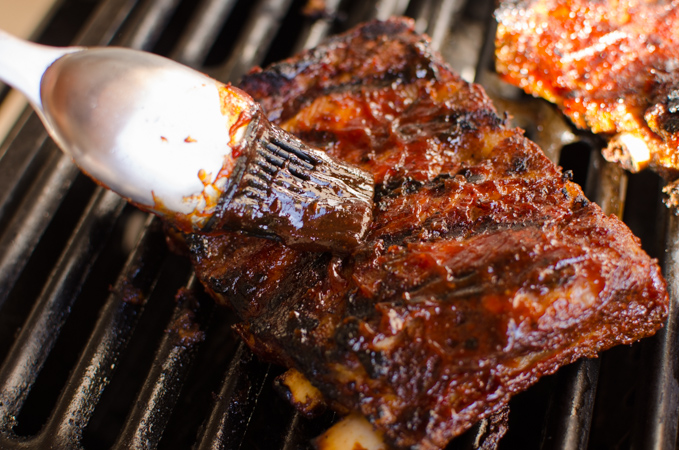 Apply homen\bade barbecue sauce to pork ribs as you grill them