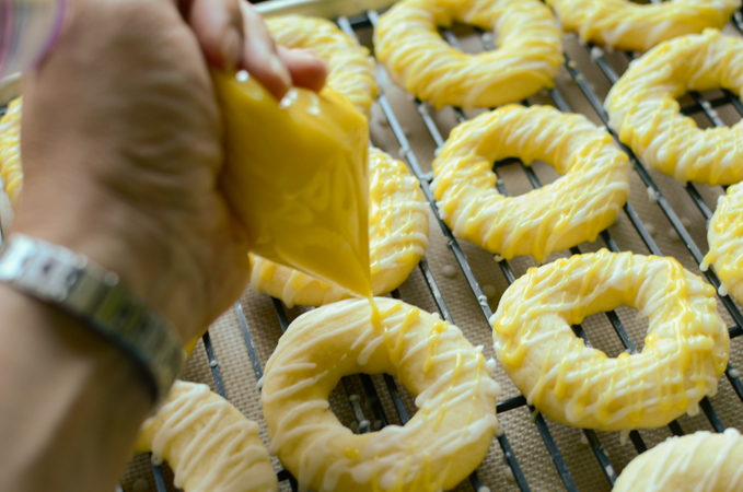 Yellow colored icing drizzled over cookies.