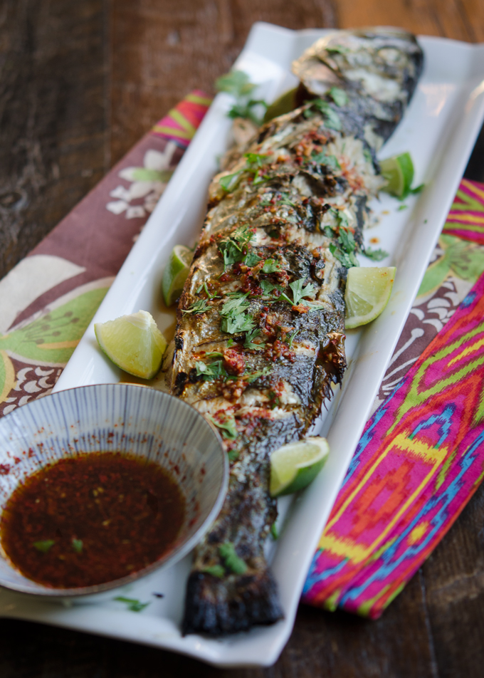 Grilled Fish is served with Soy Lime Chili Sauce and lime wedges.