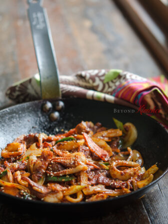 Pork belly and squid are stir-fried in a spicy sauce made with Korean chili paste and curry powder.