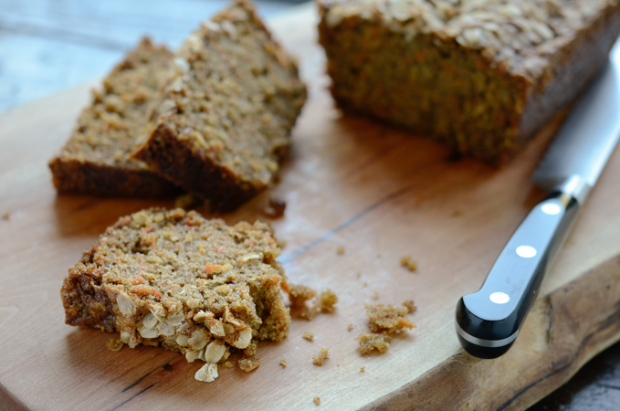 A sliced of carrot oat bread shows tender crumbs.