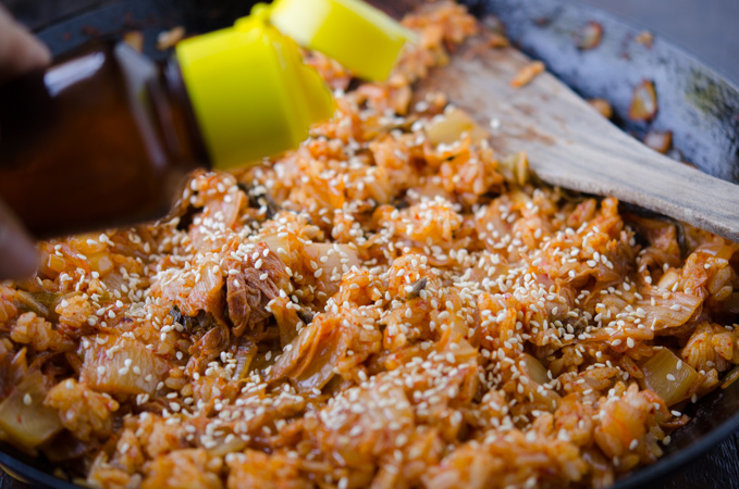 Toasted sesame seeds and sesame oil added to bacon kimchi fried rice.