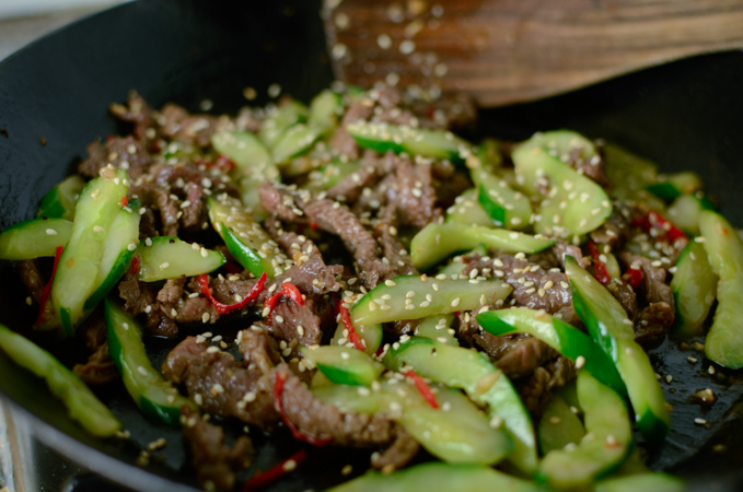 Beef and cucumber stir-fry is garnished with toasted sesame seeds.