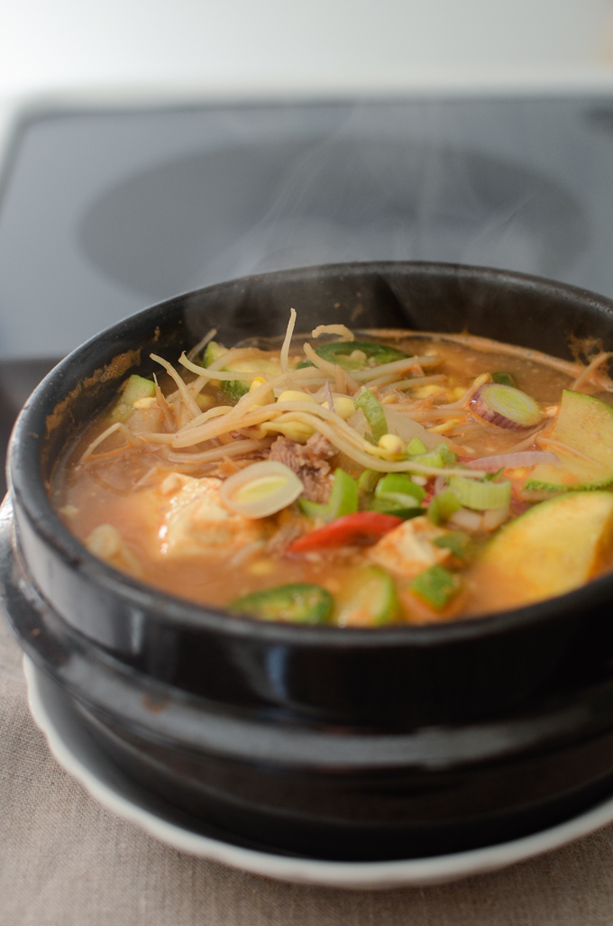 Beef Bean Sprout Soybean Paste Stew is simmered in a Korean stone pot