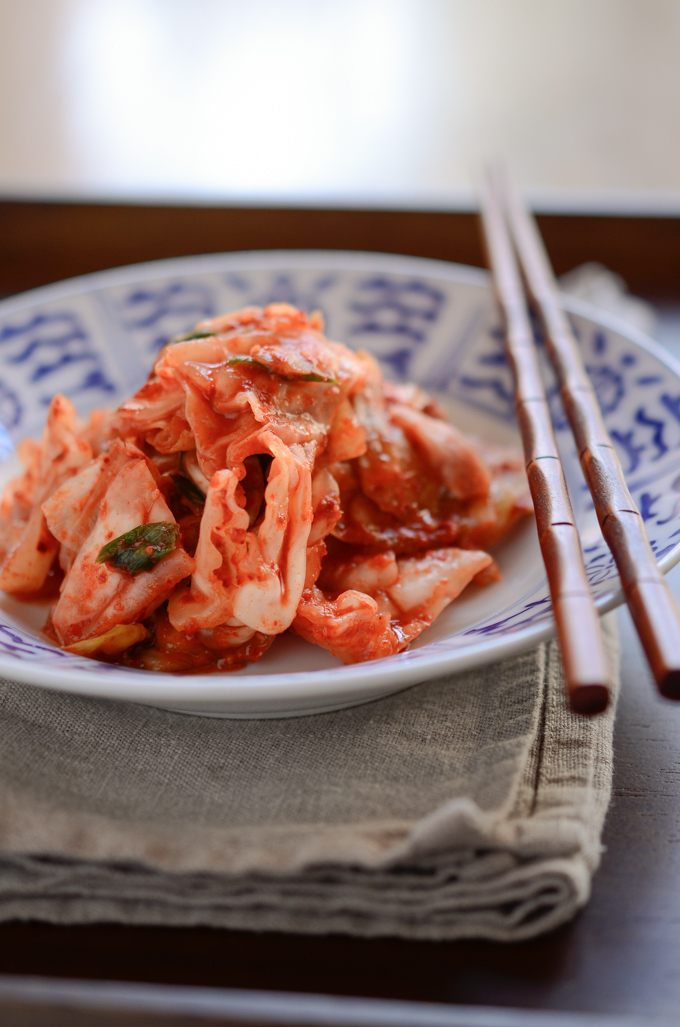 This green cabbage Kimchi in a blue bowl has a crisp texture and vibrant red color.