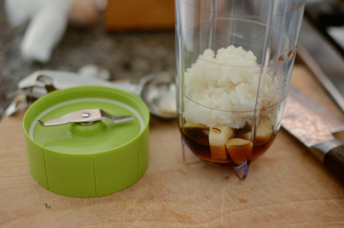 A small amount of rice, garlic, anchovy sauce is combined in a mini blender.
