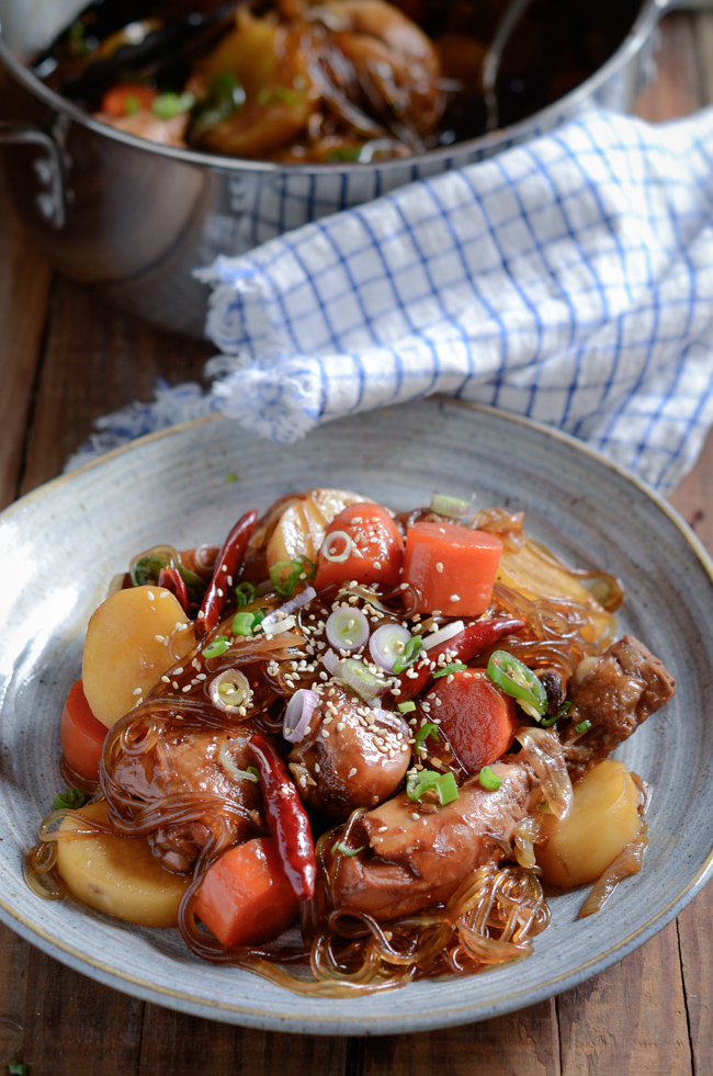 Korean Braised Chicken (Andong jjimdak) is simmered with onion, carrot, potato, and sweet potato noodles.