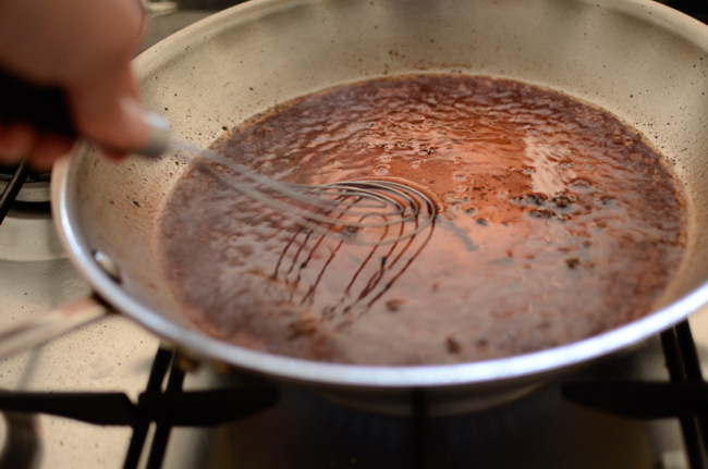 A whisk is used to make red wine reduction sauce for hambagu.