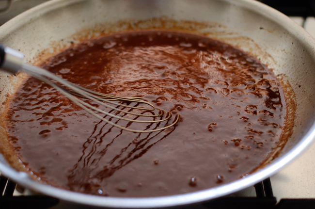 Red wind reduction sauce is made in a skillet for Japanese hamburger steak recipe.