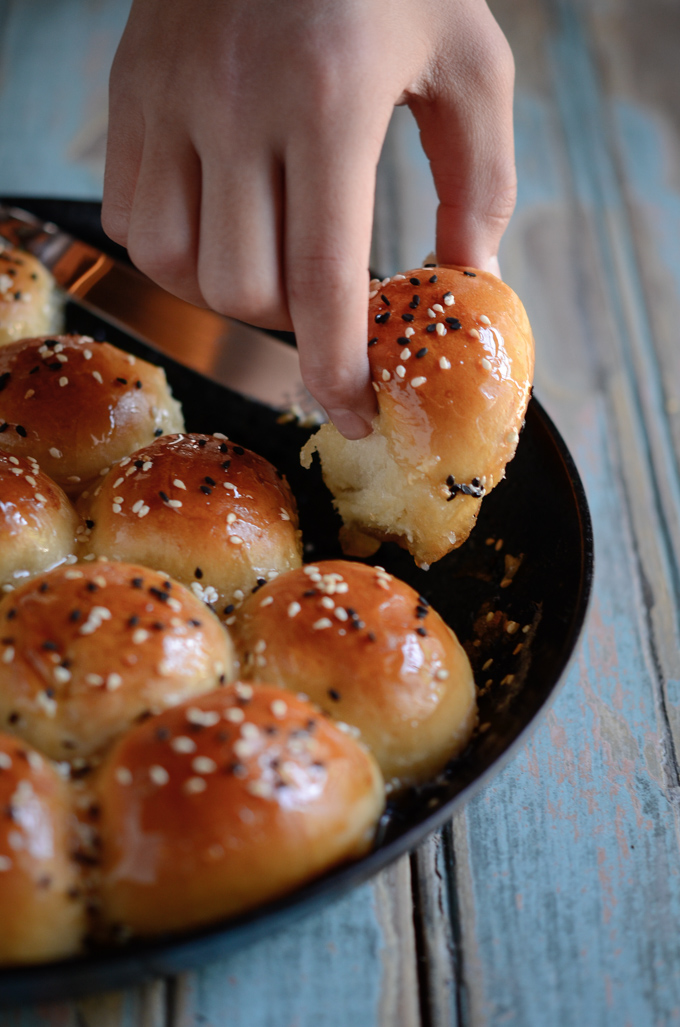 A hand is picking out one beehive buns from the skillet.