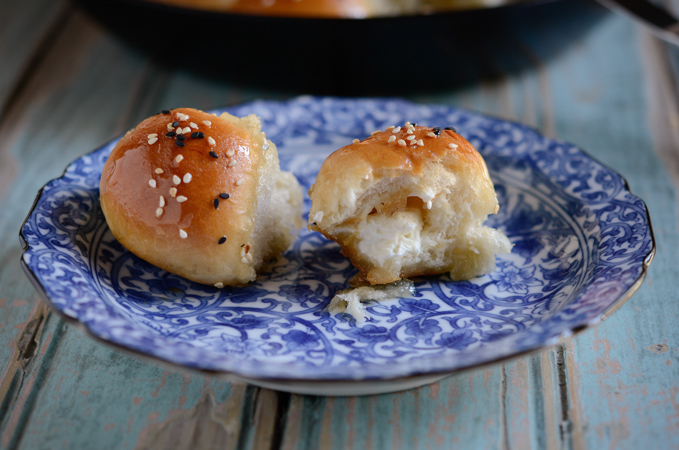 Beehive Sweet Buns placed on a blue plate are showing the cream cheese filling inside.