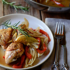 Chicken parts are roasted with fennel, pepper, onion and garnished with fresh rosemary.