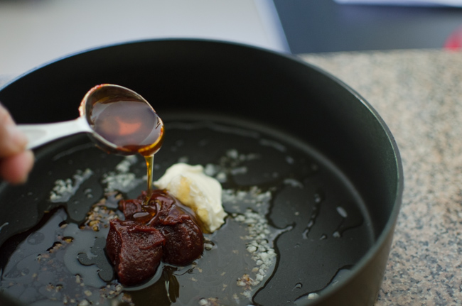 Gochujang and other seasonings are added to a skillet.