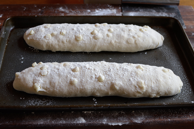 White chocolate bread dough loaves are dusted with flour before the second rise.