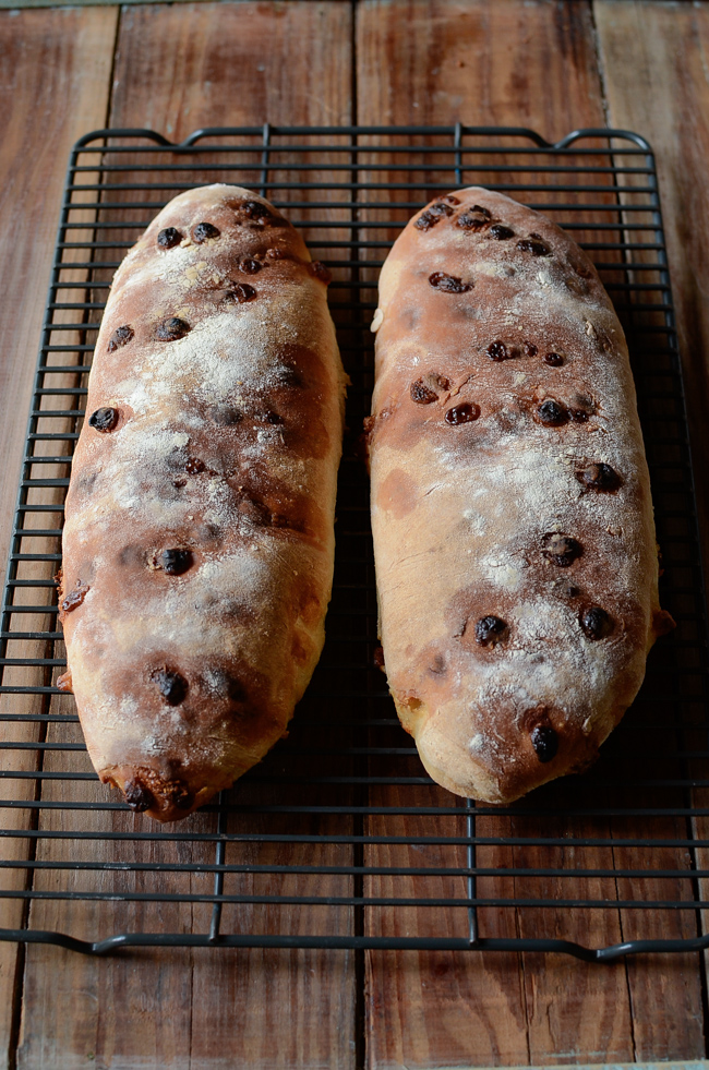 Two loaves of club med white chocolate bread are cooling on a wired rack.