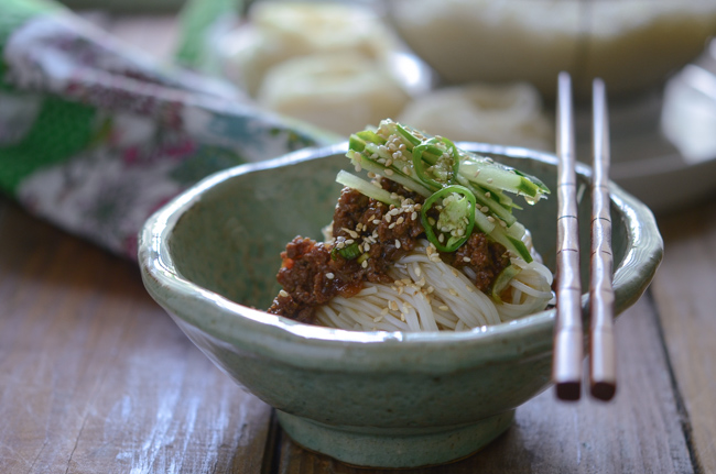 Korean Noodles are topped with Beef Sauce and cucumber slices.