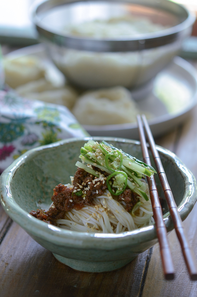 Korean cold vermicelli noodles are topped with Beef Sauce and cucumber.
