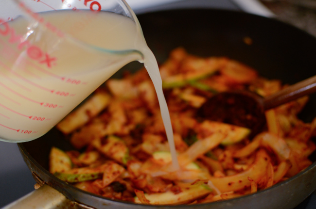 Chicken stock is added to spicy vegetable mixture.