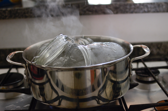 Glass jars are sterilizing in a pot of boiling water.