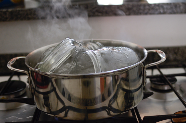 Glass jars a re sterilizing in a pot of boiling water