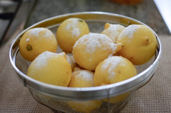 A basket of whole lemon are sprinkled with baking soda.