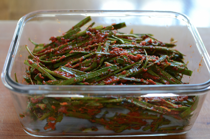 Garlic Chives Kimchi (Buchu kimchi, 부추김치) is stored in a glass container.