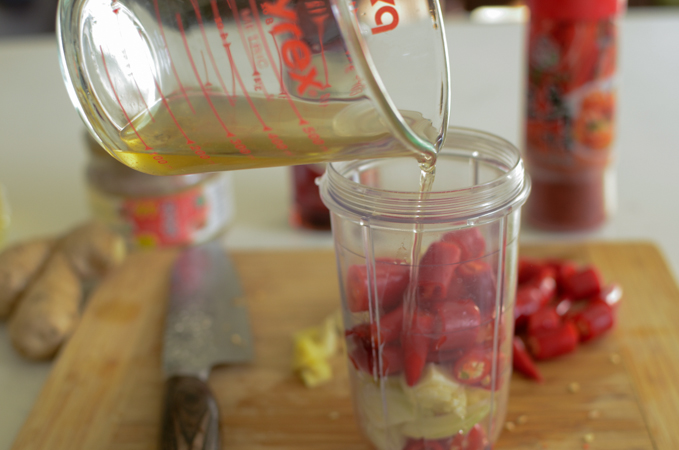Stock added to savory ingredients in a mini blender.