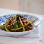 Turnip kimchi is served in a blue and white bowl over a white kitchen towel.