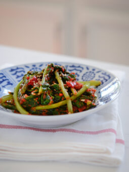 Turnip kimchi is served in a blue and white bowl over a white kitchen towel.