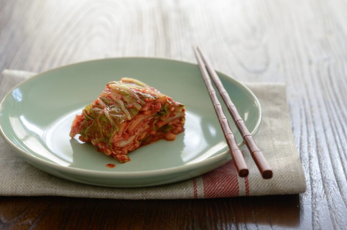 Cabbage Kimchi is nicely sliced and served with chopsticks