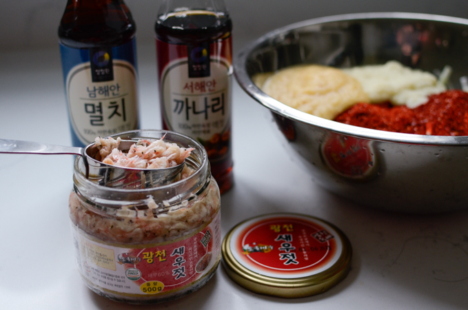 A jar of Korean salted shrimp is presented next to other fish sauces.