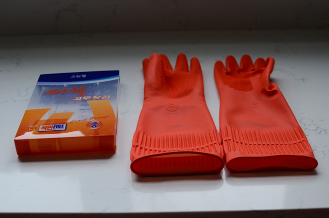A pair of red plastic gloves are shown.