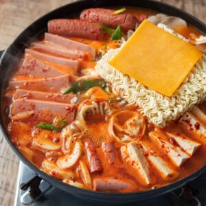 Korean budae jjigae with spam, sausage, ramen, and cheese in spicy broth