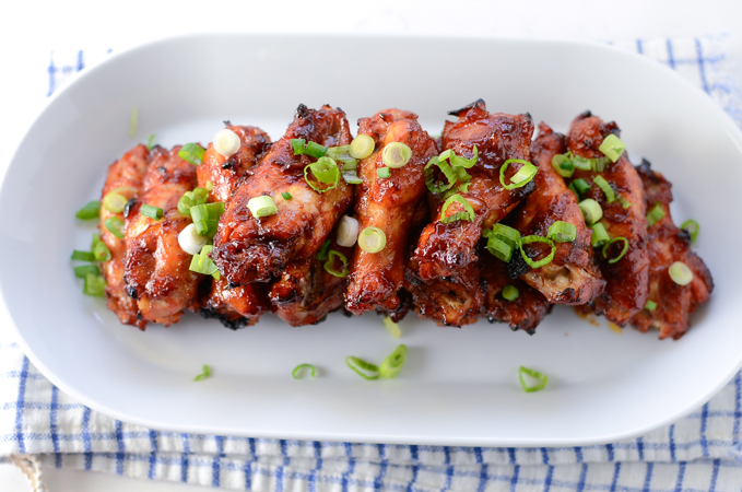 Baked Sweet and Spicy Sticky Chicken Wings are garnished with chopped green onion.